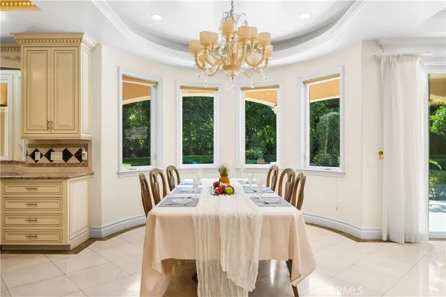 a view of a dining room with furniture a chandelier and large window