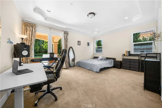 a bedroom with a bed a table and a large window