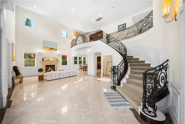 a view of a livingroom with furniture a fireplace a ceiling fan and windows
