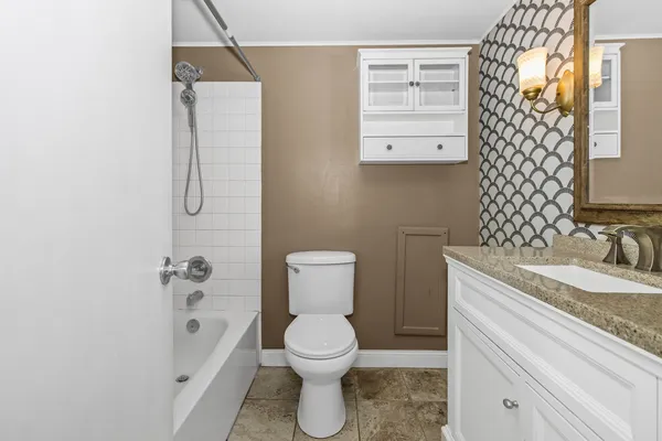 a bathroom with a granite countertop sink toilet and shower