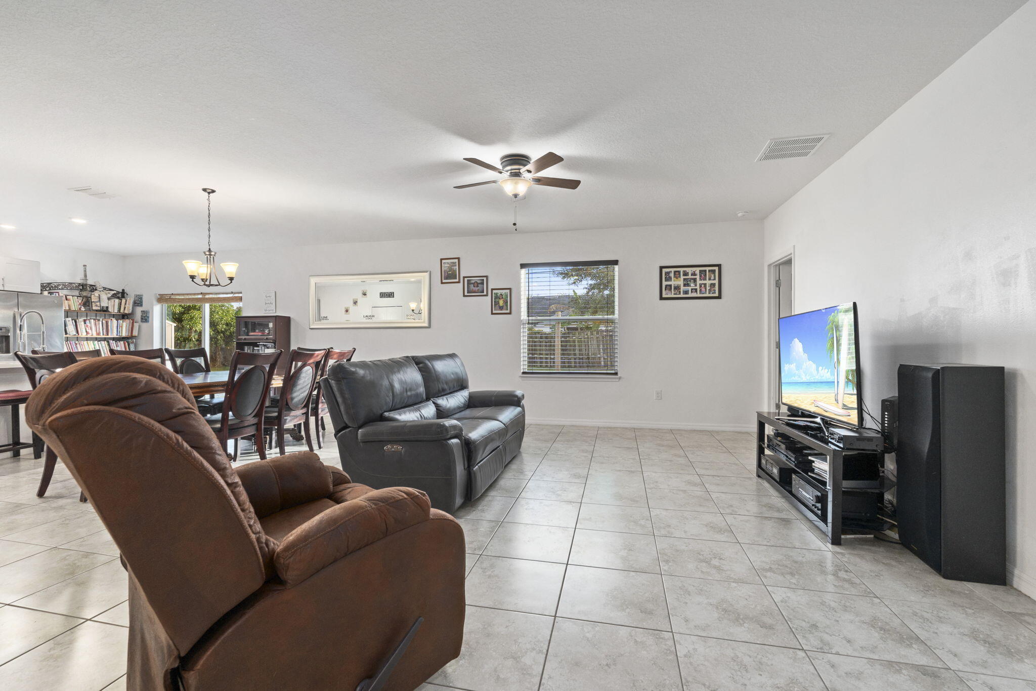 1414 Southwest Crest Avenue Port St. Lucie, FL 34953 - Photo 12 of 41 a living room with furniture a ceiling fan and a window