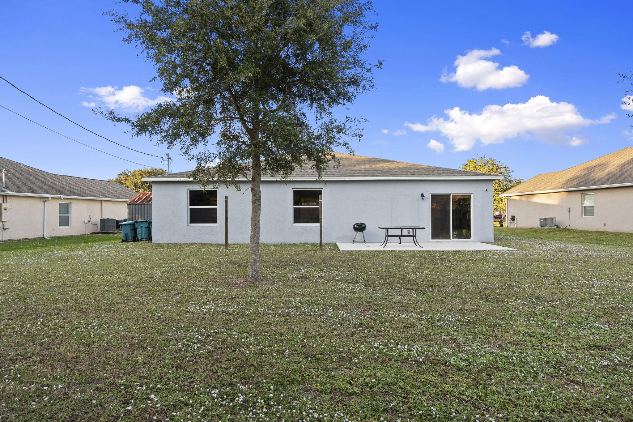 1414 Southwest Crest Avenue Port St. Lucie, FL 34953 - Photo 35 of 41 a view of a yard with a house and a large tree