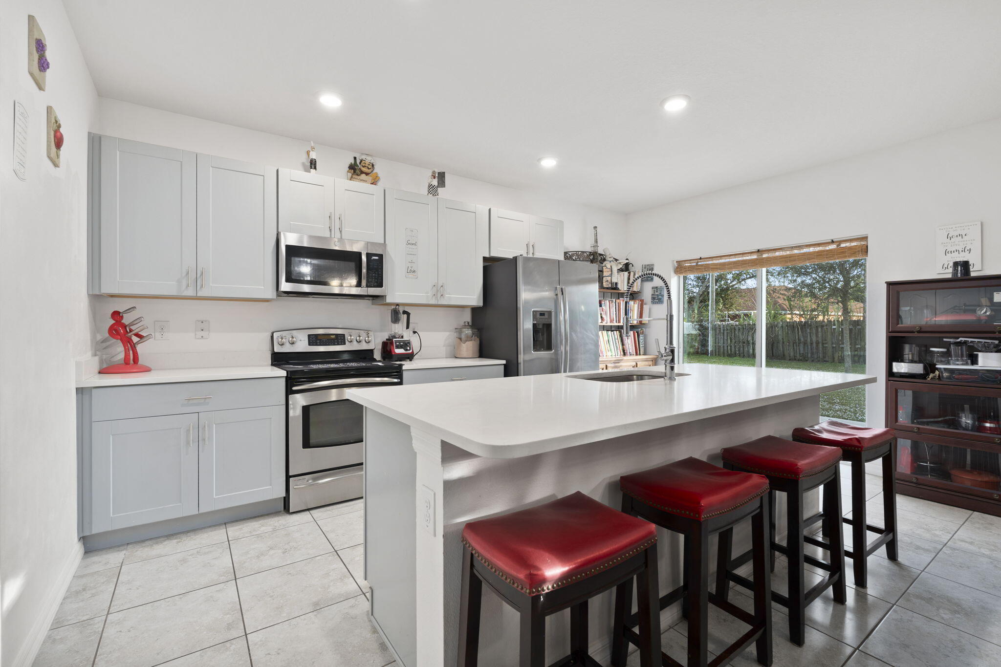 1414 Southwest Crest Avenue Port St. Lucie, FL 34953 - Photo 4 of 41 a kitchen with kitchen island white cabinets and stainless steel appliances