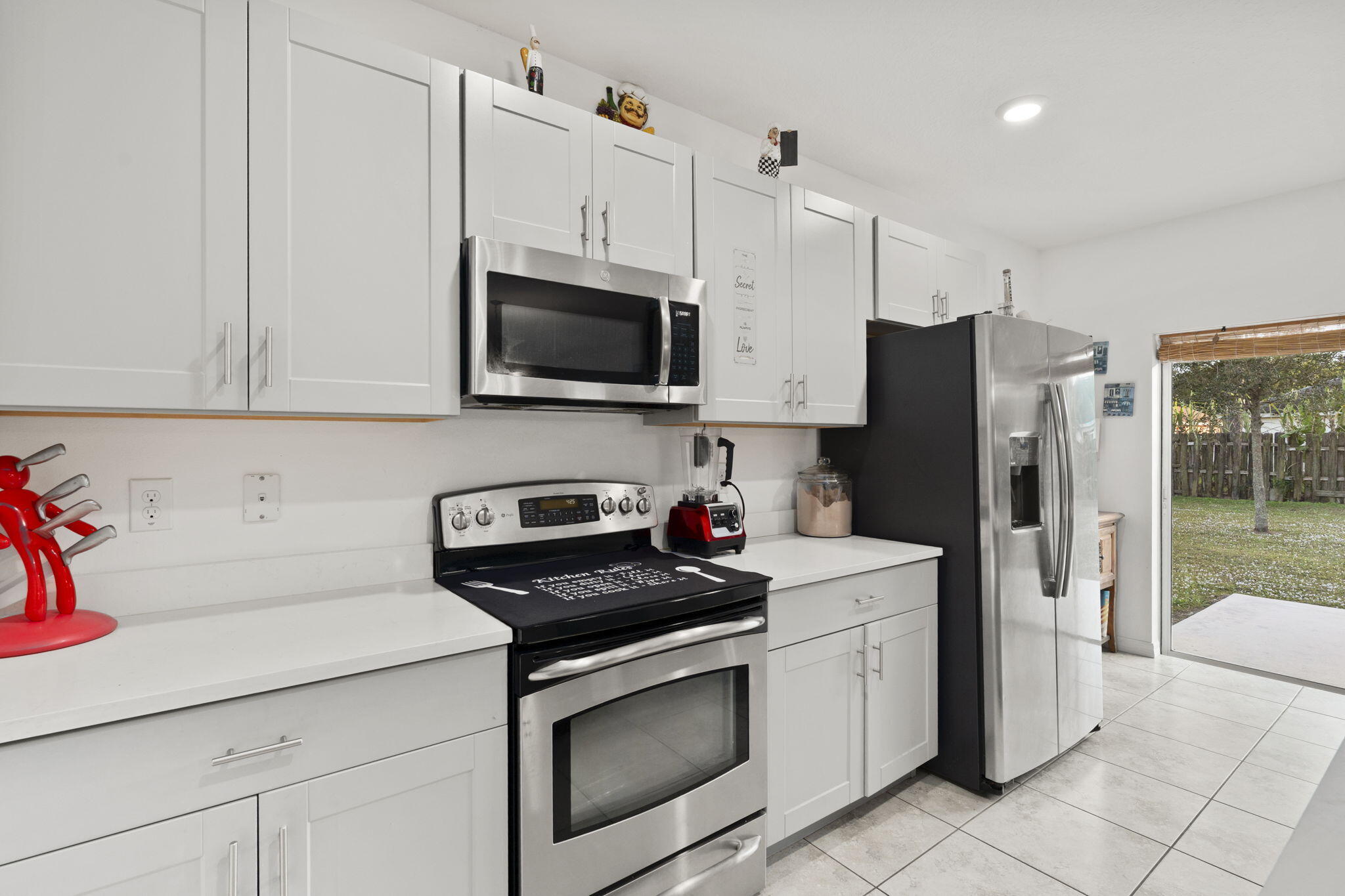 1414 Southwest Crest Avenue Port St. Lucie, FL 34953 - Photo 5 of 41 a kitchen with stainless steel appliances a refrigerator stove and microwave