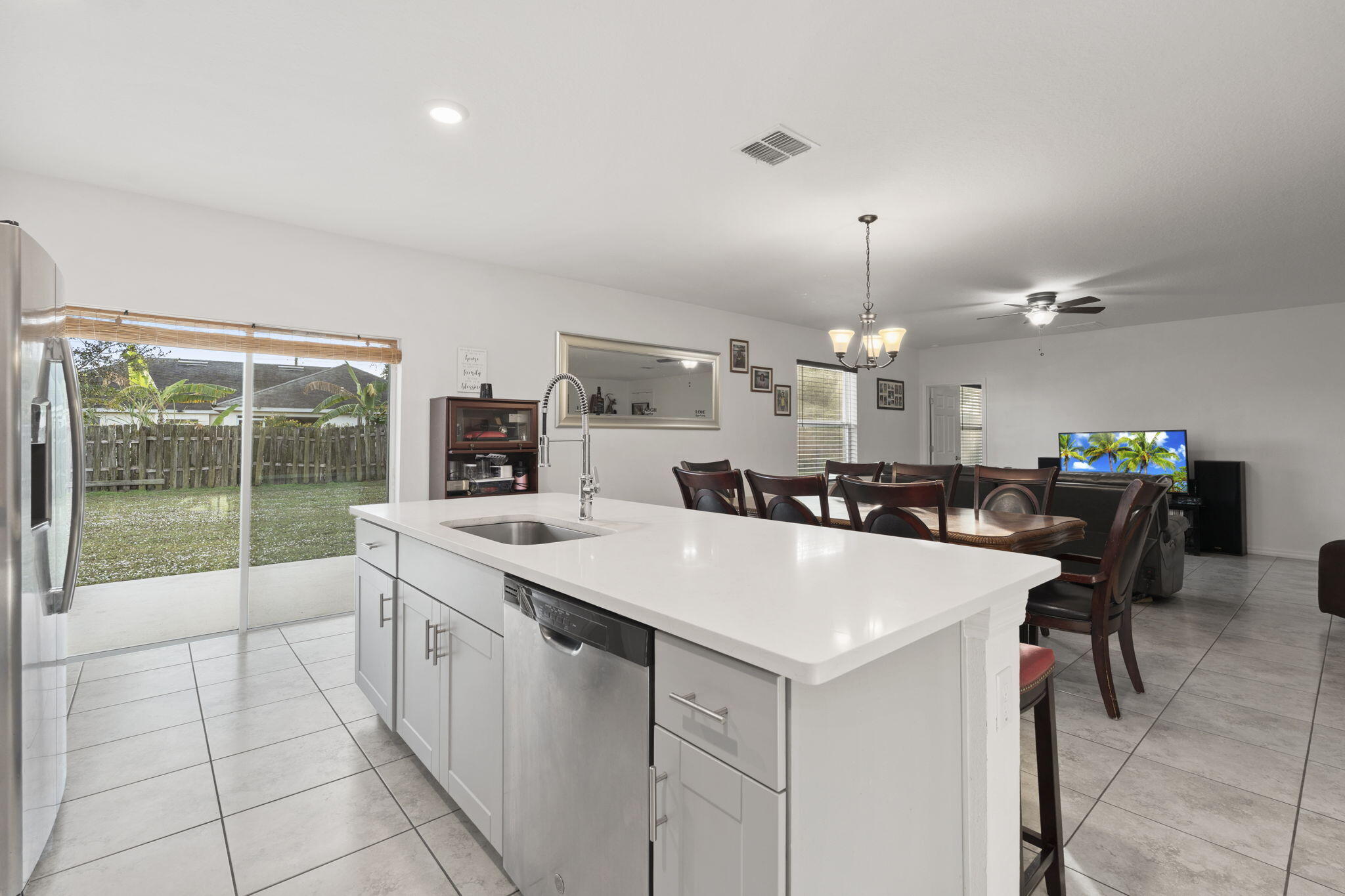 1414 Southwest Crest Avenue Port St. Lucie, FL 34953 - Photo 7 of 41 a large white kitchen with a stove a table and chairs