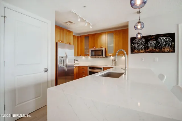 a large kitchen with kitchen island a large counter space appliances and a sink
