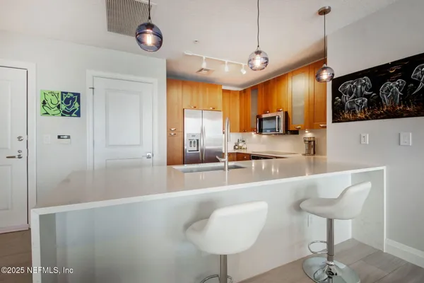 a large kitchen with kitchen island a large counter space a sink stainless steel appliances and cabinets