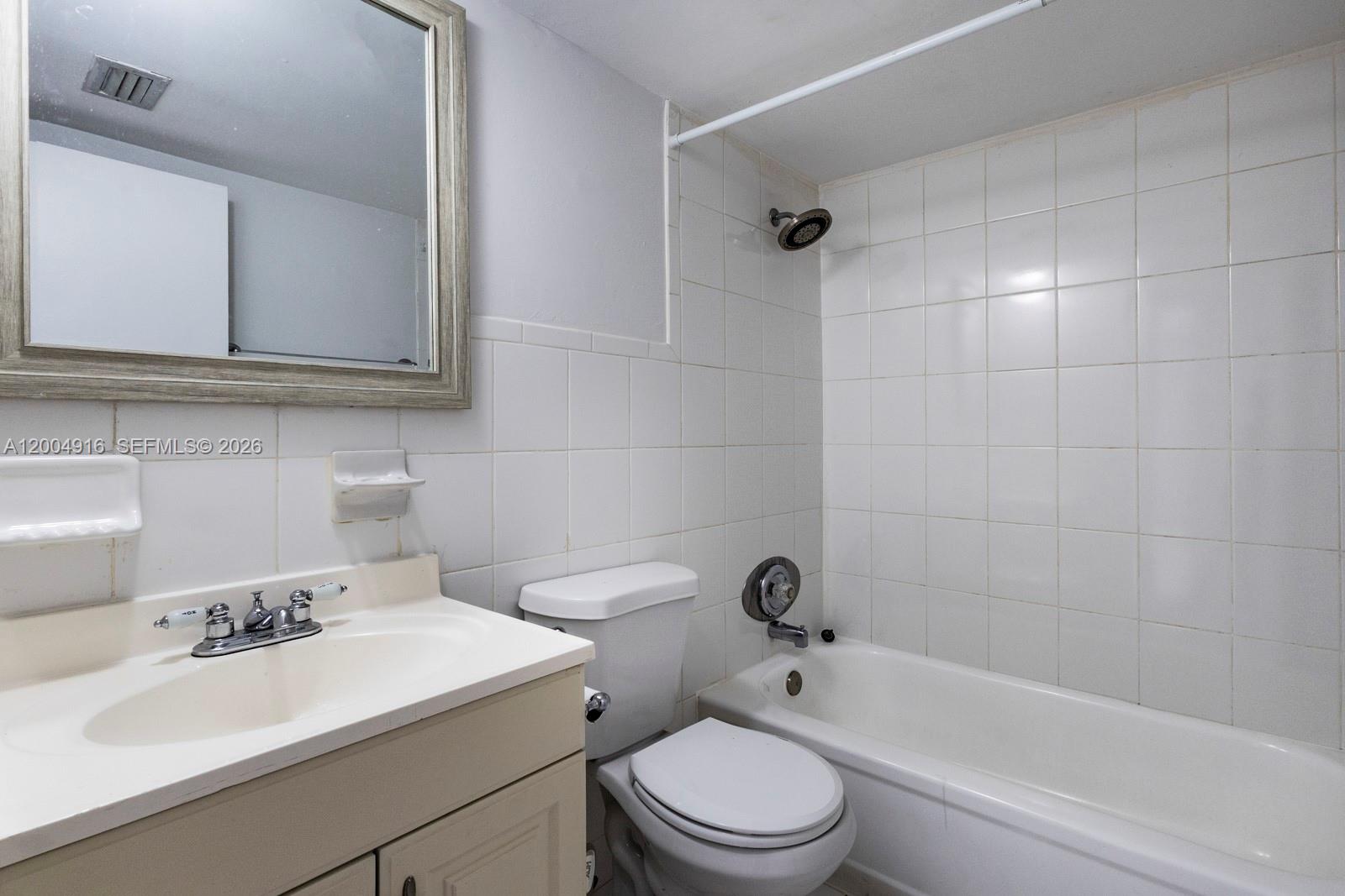 7747 Southwest 86th Street, Unit D205 Miami, FL 33143 - Photo 13 of 15 a bathroom with a sink a toilet and bathtub