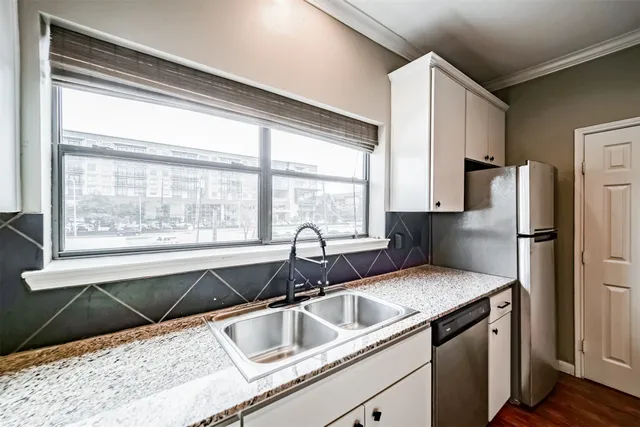a kitchen with granite countertop a sink and a refrigerator