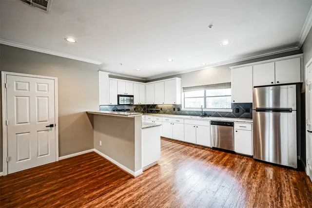 a kitchen with a refrigerator and white cabinets