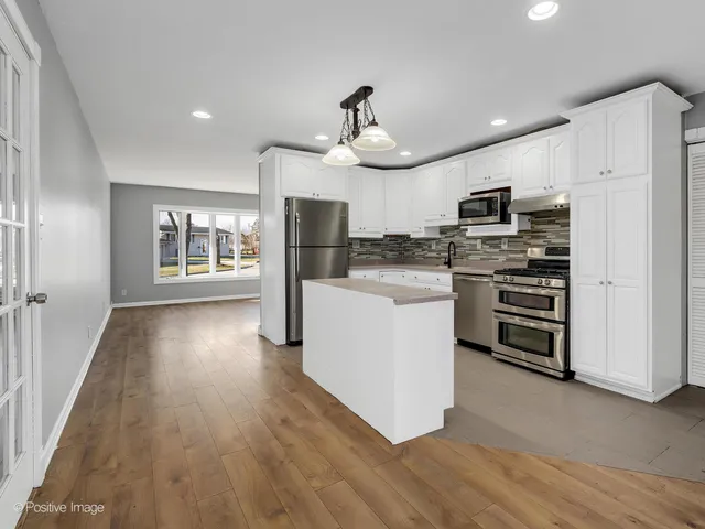 a kitchen with stainless steel appliances a stove top oven and refrigerator