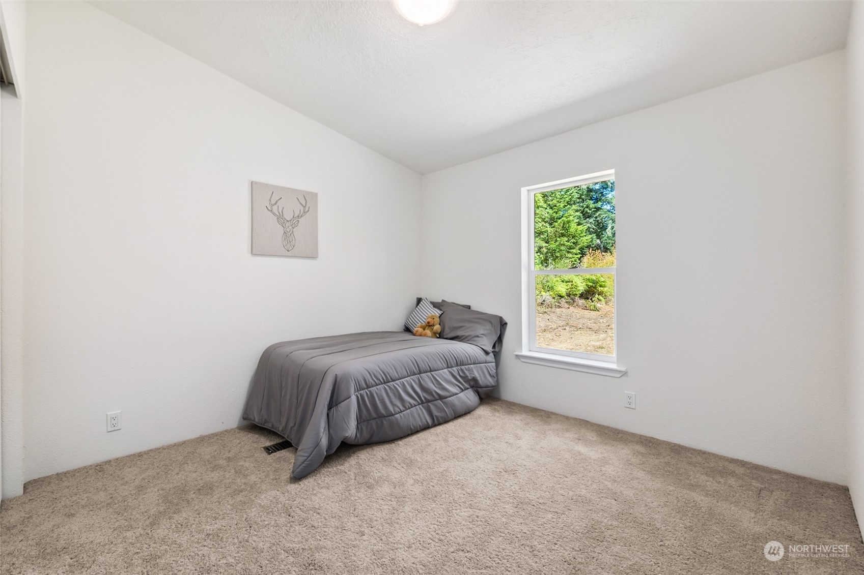 271 East Leffler Loop Road Grapeview, WA 98546 - Photo 18 of 36 a bed sitting in a bedroom next to a window