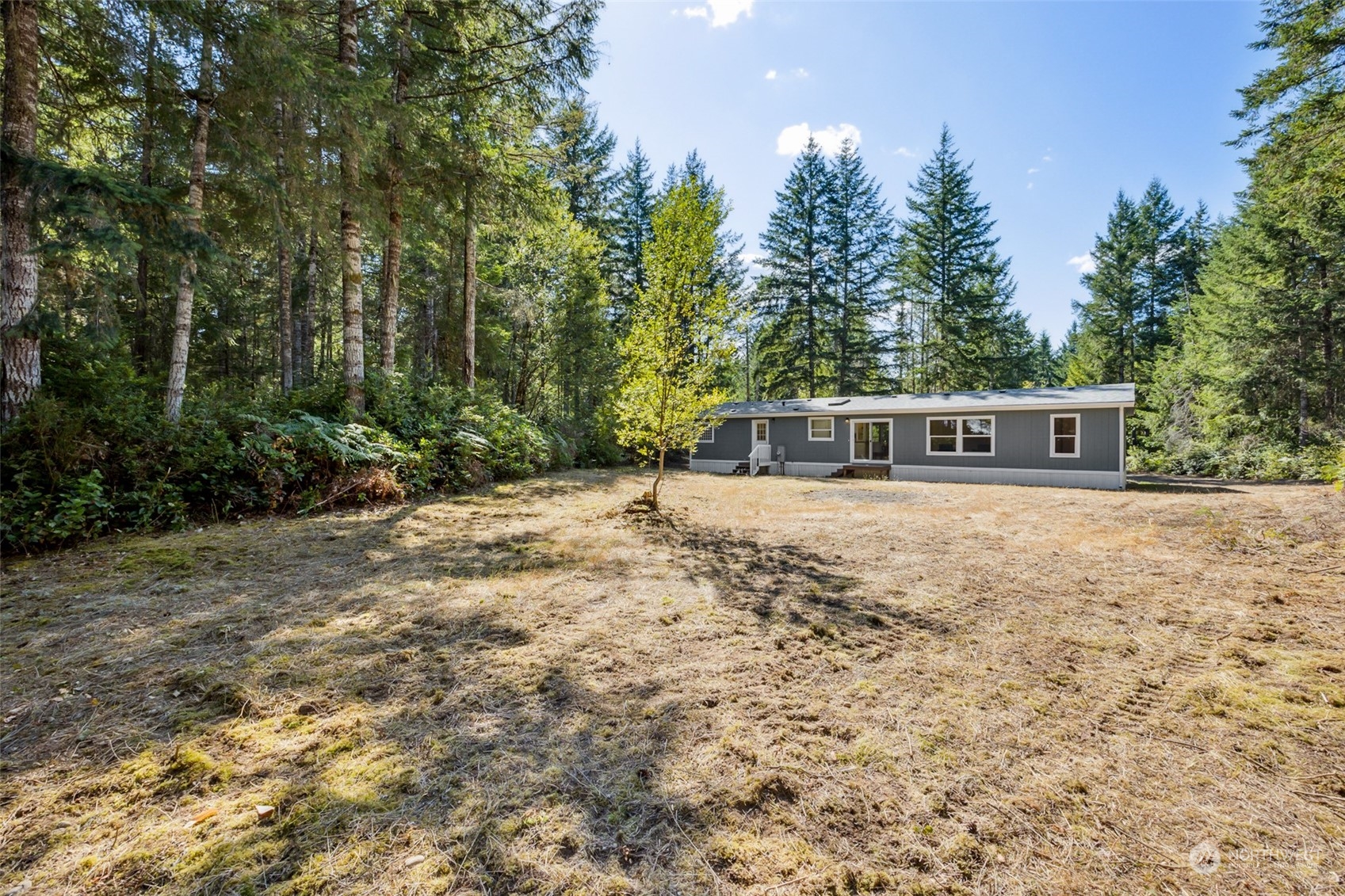 271 East Leffler Loop Road Grapeview, WA 98546 - Photo 27 of 36 a house with trees in the background