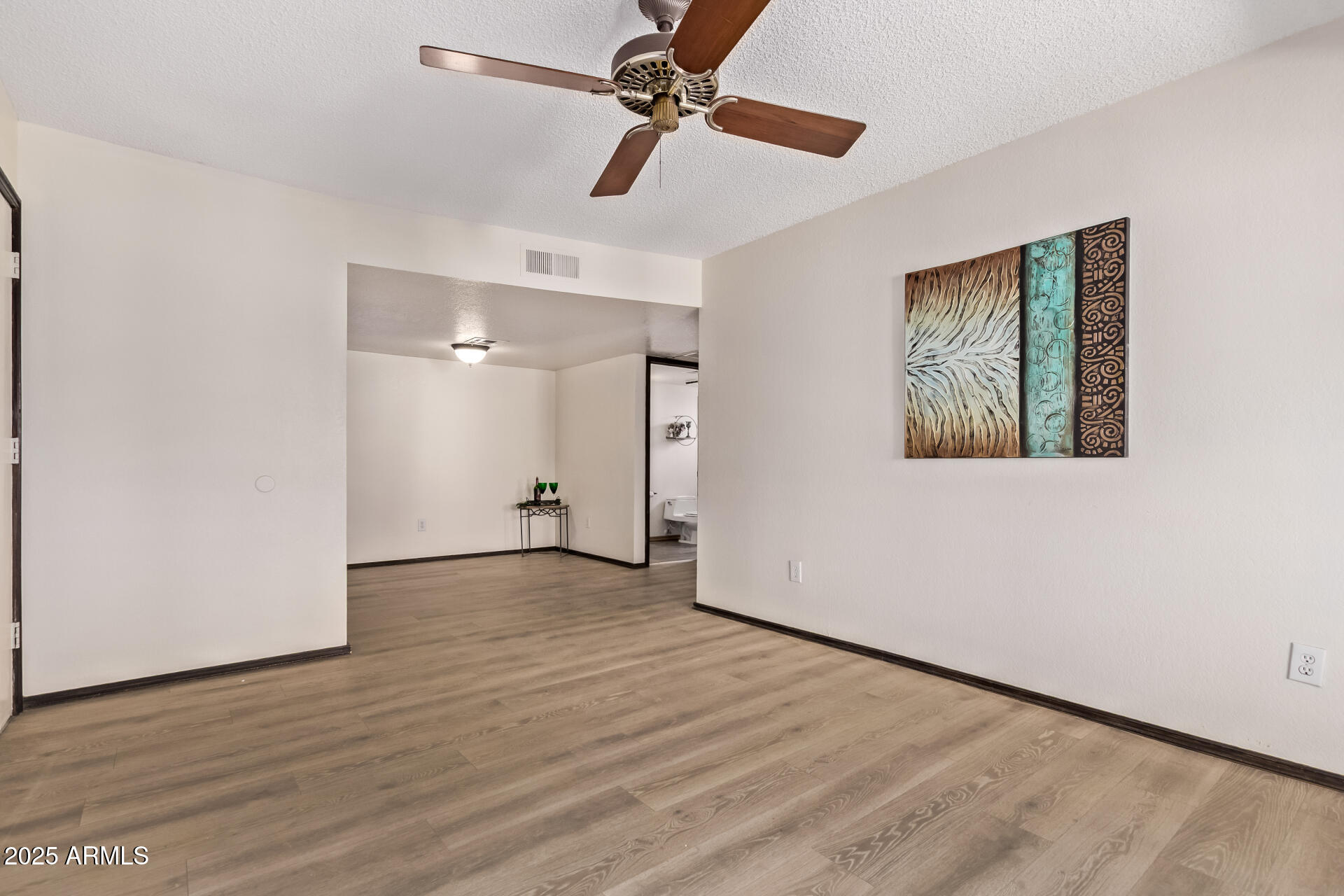 729 West Coolidge Street, Unit 211 Phoenix, AZ 85013 - Photo 6 of 21 a view of an empty room with wooden floor and a ceiling fan