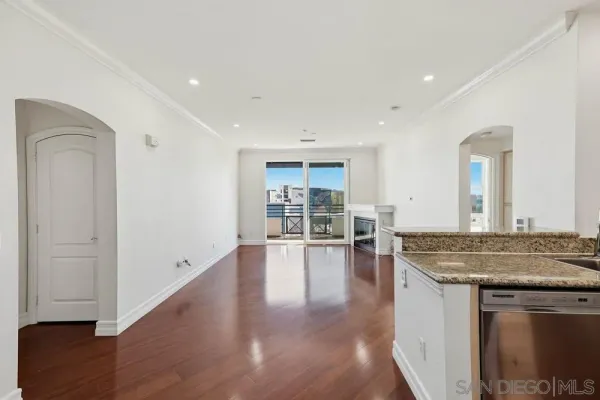 a kitchen with stainless steel appliances granite countertop a refrigerator a stove and a sink with wooden floor