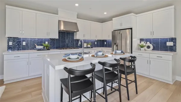 a kitchen with a dining table chairs refrigerator and cabinets