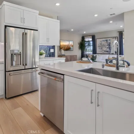 a kitchen with stainless steel appliances granite countertop a refrigerator a sink a stove a microwave and island