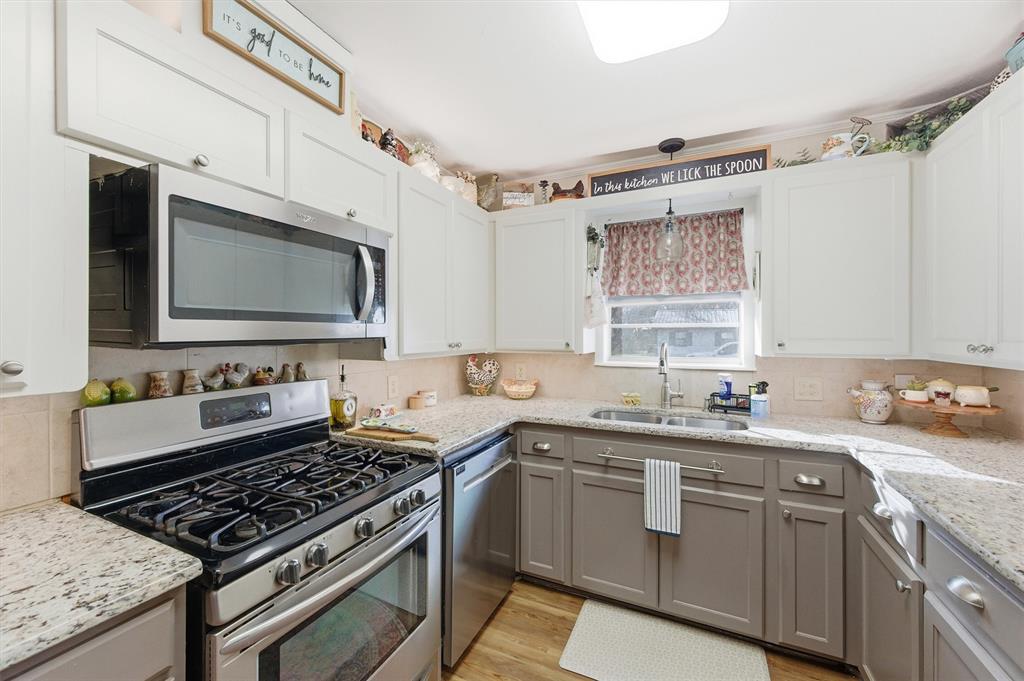 515 Pecan Street Collinsville, TX 76233 - Photo 11 of 39 a kitchen with stainless steel appliances a sink dishwasher stove microwave and cabinets