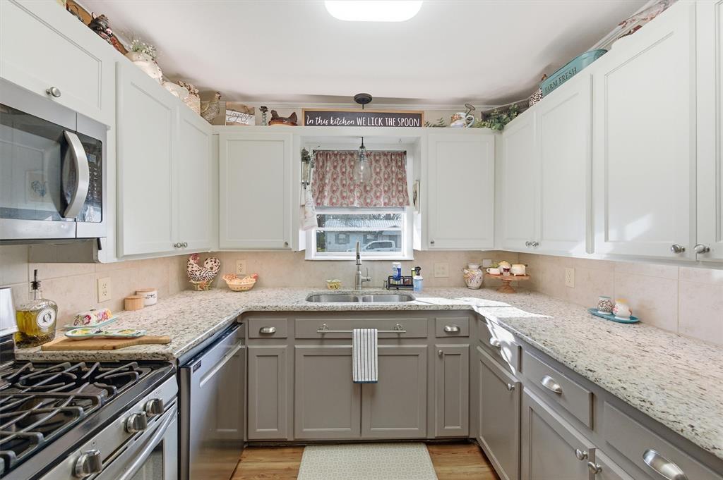 515 Pecan Street Collinsville, TX 76233 - Photo 12 of 39 a kitchen with stainless steel appliances granite countertop a sink stove and cabinets