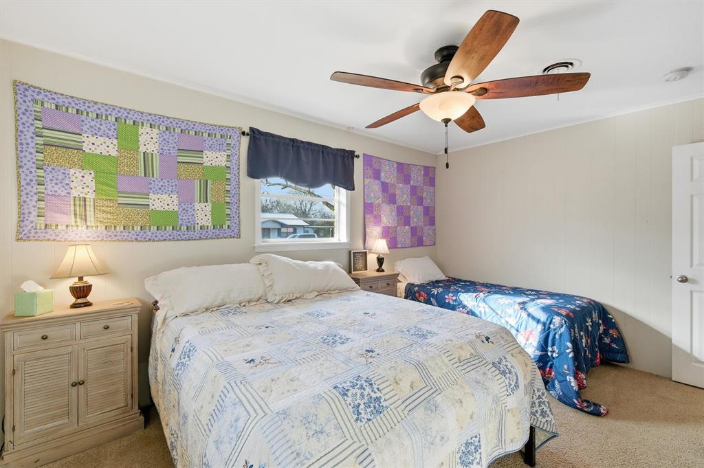 515 Pecan Street Collinsville, TX 76233 - Photo 17 of 39 a bedroom with a large bed and a chandelier