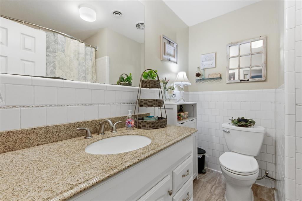515 Pecan Street Collinsville, TX 76233 - Photo 18 of 39 a bathroom with a granite countertop toilet sink and mirror
