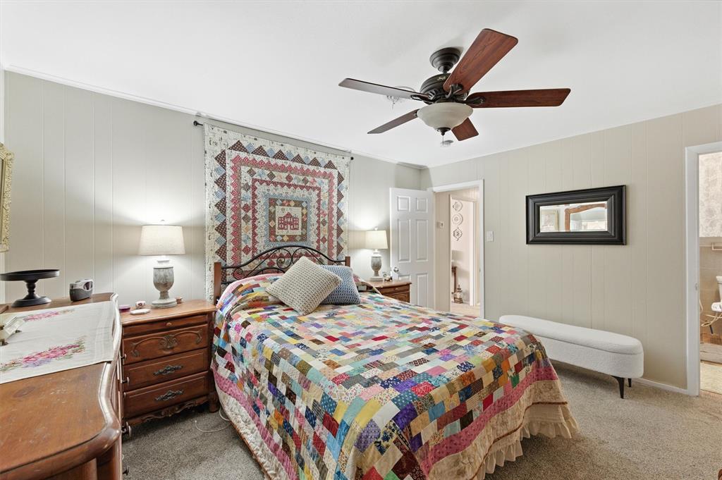 515 Pecan Street Collinsville, TX 76233 - Photo 21 of 39 a bedroom with a bed and a chandelier