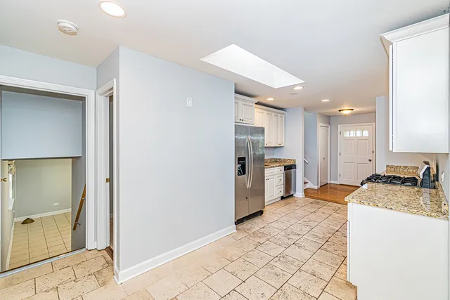 a large kitchen with a sink stainless steel appliances and cabinets