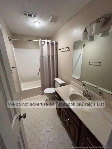 a bathroom with a granite countertop sink a toilet and shower