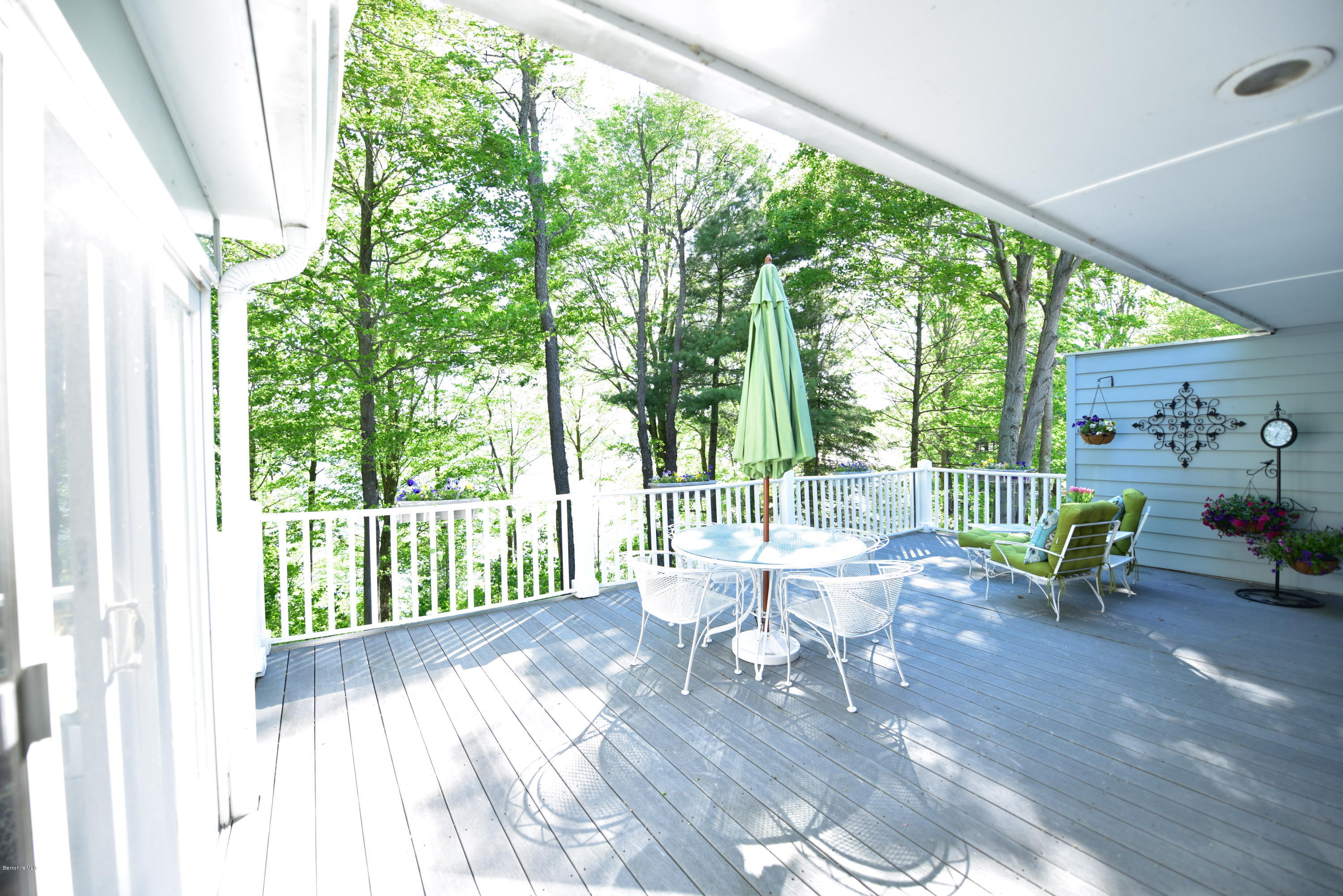 1136 Barker Road, Unit 36 Pittsfield, MA 01201 - Photo 21 of 28 a view of a patio with table and chairs and wooden floor