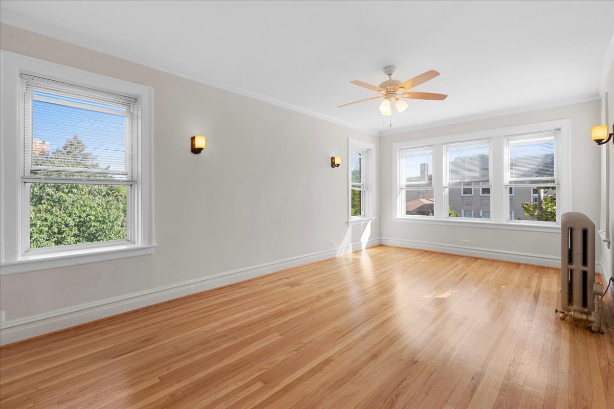 120 Custer Avenue, Unit 3 Evanston, IL 60202 - Photo 3 of 15 a view of an empty room with a window and wooden floor