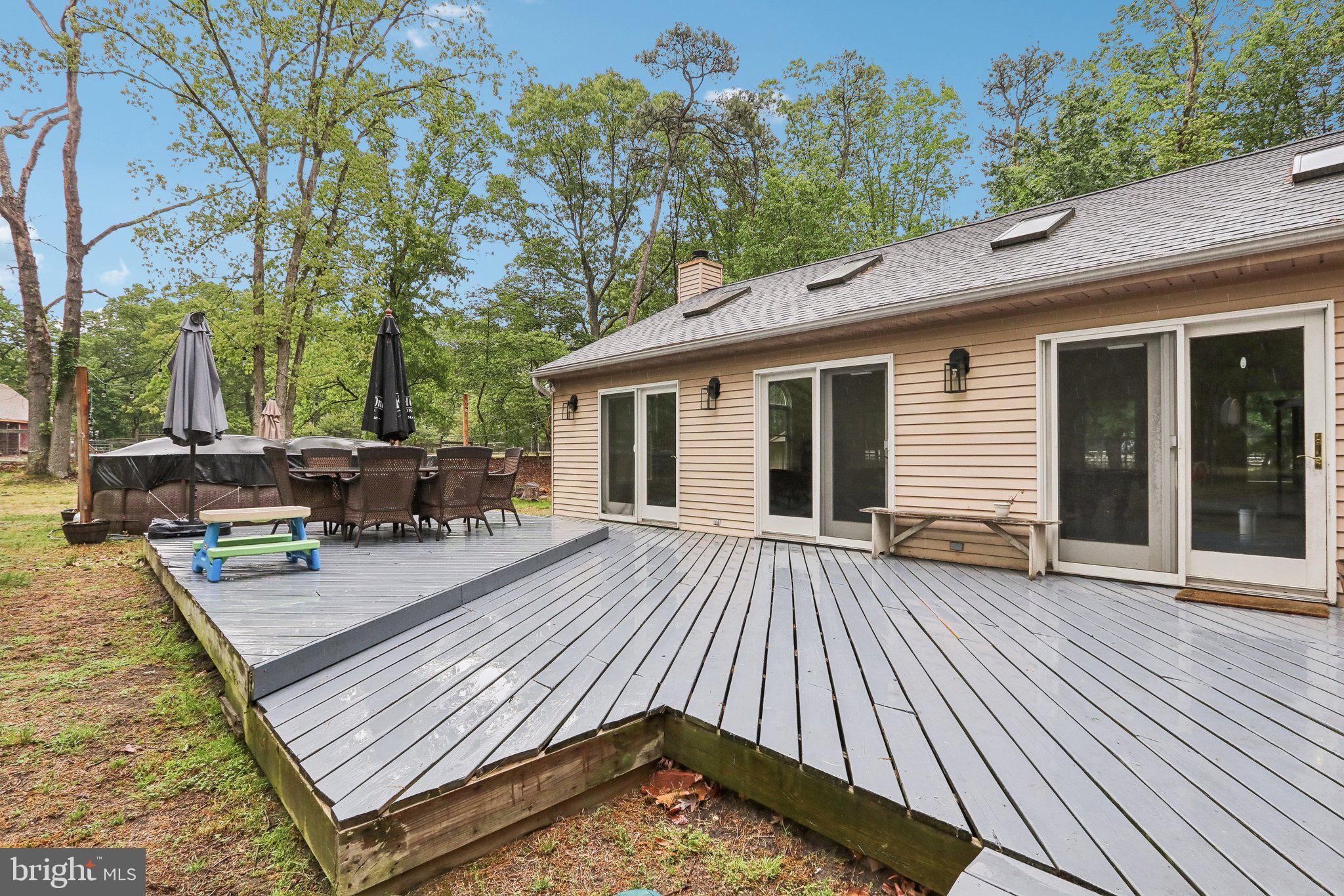 595 Tabernacle Road Medford, NJ 08055 - Photo 50 of 65 a view of a roof deck with table and chairs a barbeque with wooden floor and fence