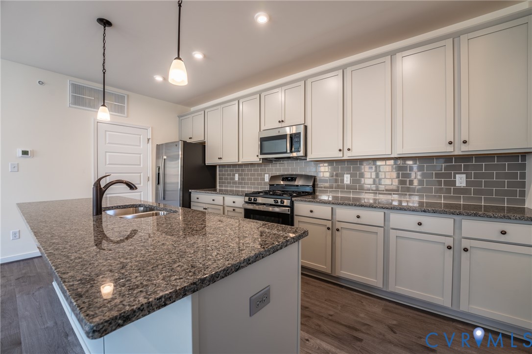4003 Next Level Trace Midlothian, VA 23112 - Photo 12 of 38 a kitchen with stainless steel appliances granite countertop a sink a stove and white cabinets