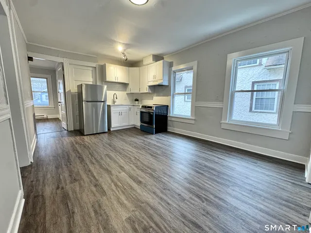 a view of a kitchen with wooden floor and electronic appliances