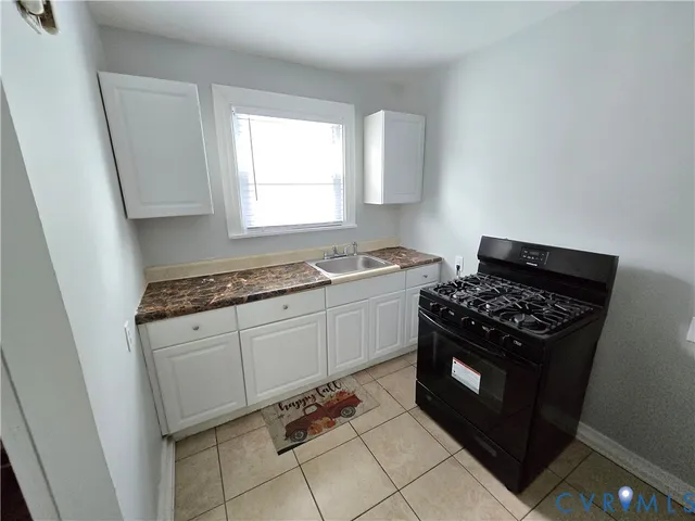 a kitchen with granite countertop a stove and a sink