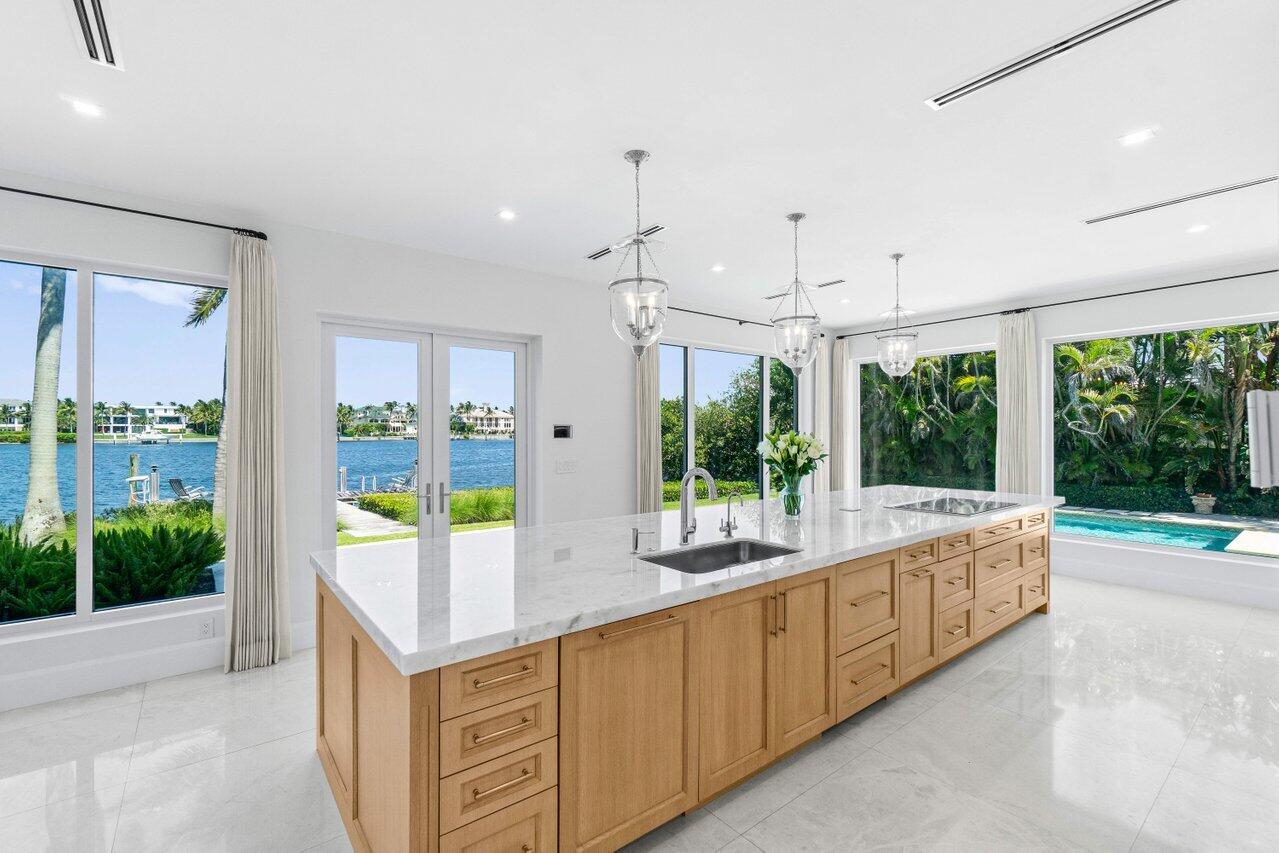 1690 Lands End Road Manalapan, FL 33462 - Photo 20 of 59 a large white kitchen with a large window and swimming pool