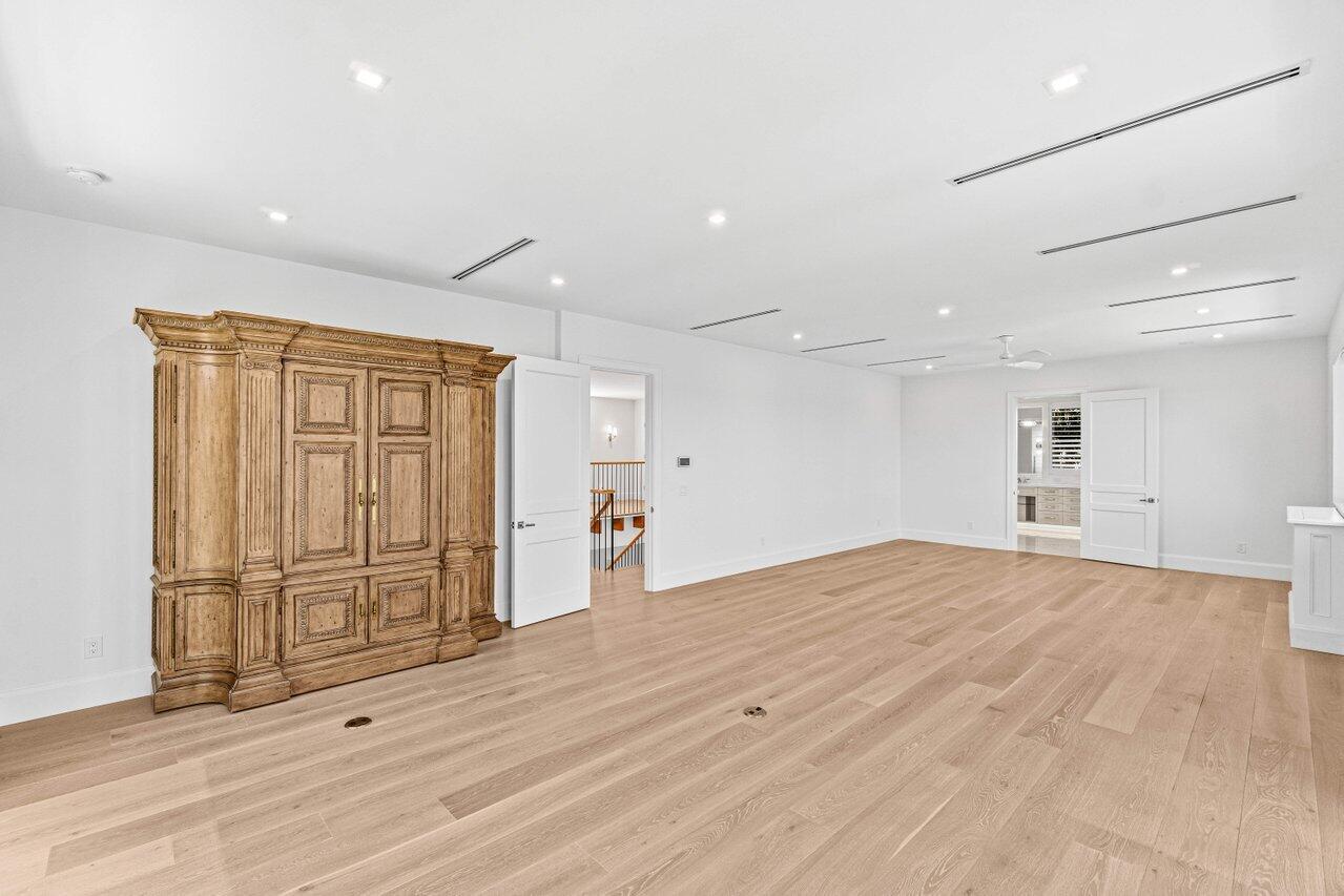 1690 Lands End Road Manalapan, FL 33462 - Photo 27 of 59 an empty room with wooden floor and windows with curtains