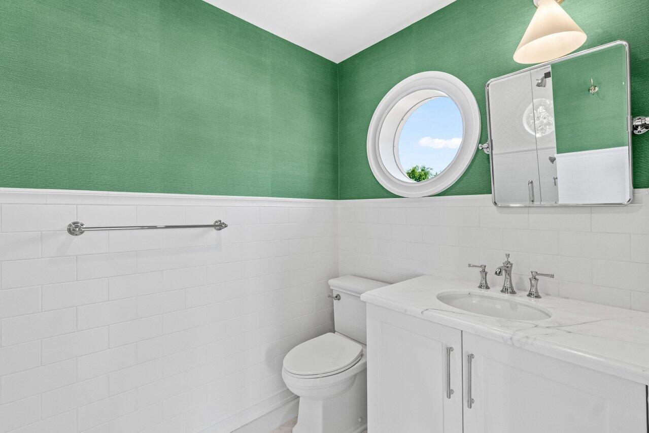 1690 Lands End Road Manalapan, FL 33462 - Photo 42 of 59 a bathroom with a toilet sink vanity and mirror