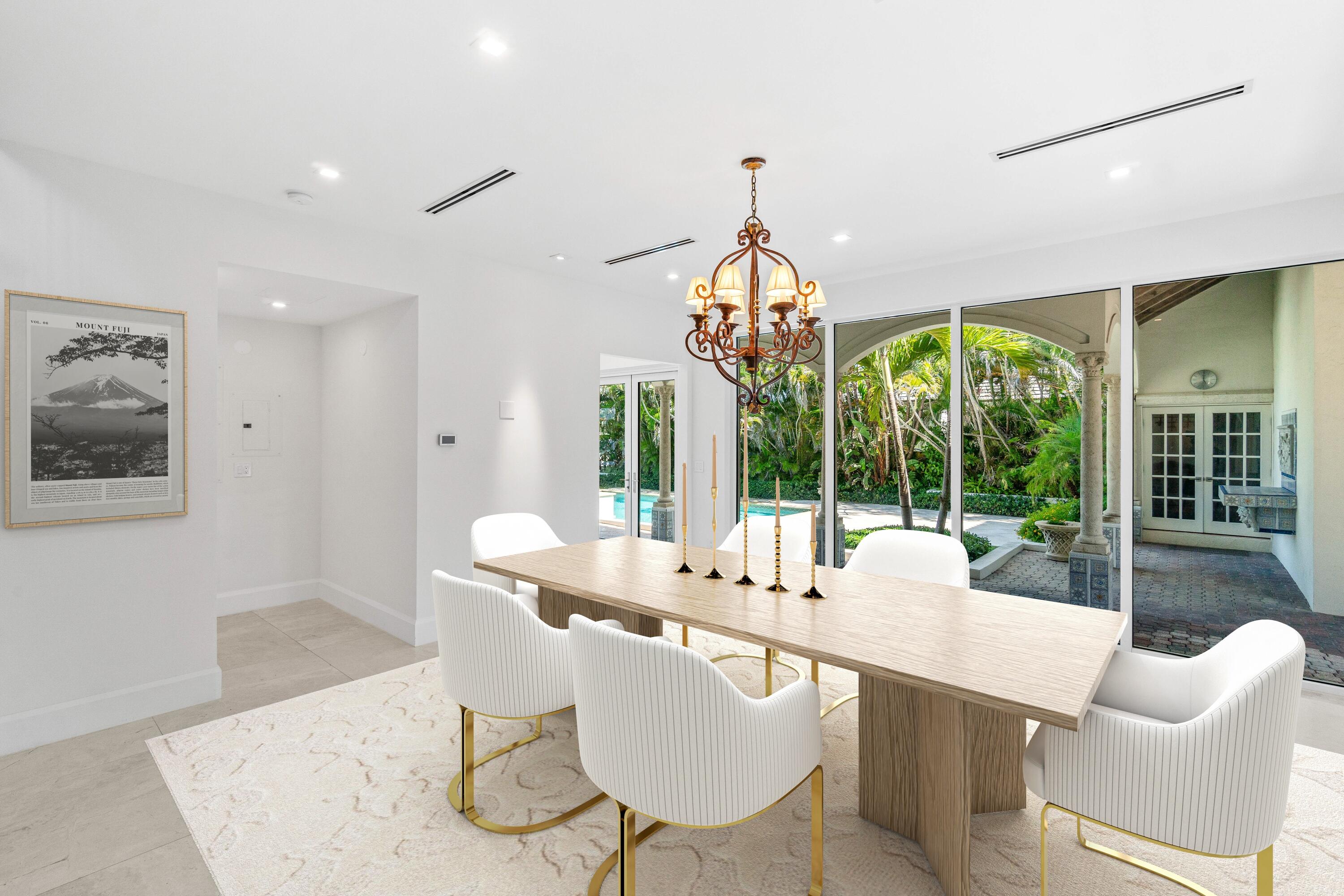 1690 Lands End Road Manalapan, FL 33462 - Photo 47 of 59 a dining room with furniture a chandelier and wooden floor