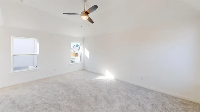 an empty room with windows and fan