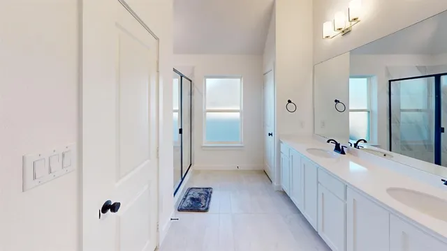 a bathroom with a double vanity sink a mirror and a bathtub