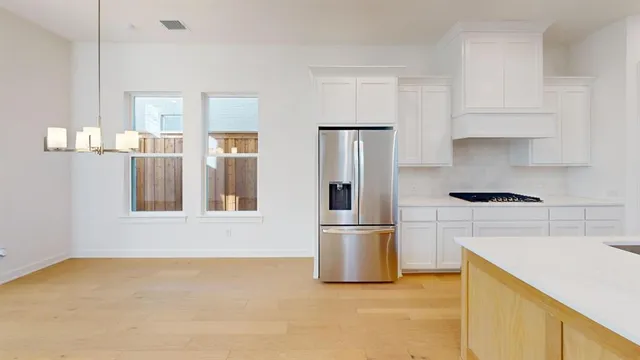 a kitchen with stainless steel appliances kitchen island a sink refrigerator and cabinets