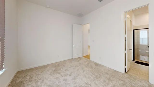 an empty room with closet and a bathroom