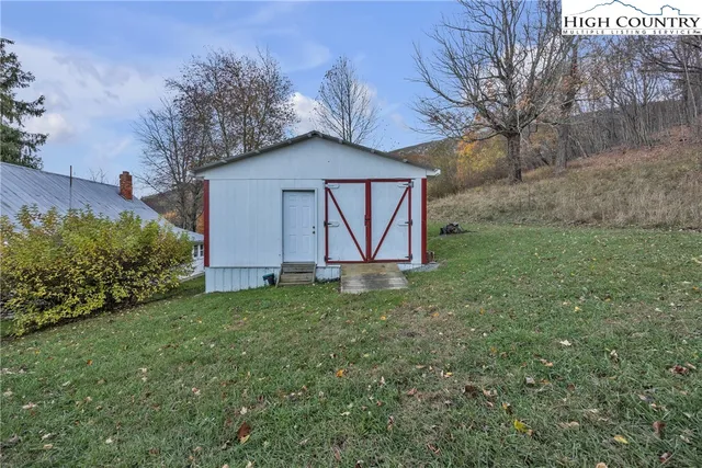 a backyard of a house with lots of green space and lake view