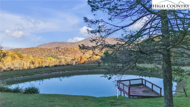 a front view of a house with a yard and mountain view in back
