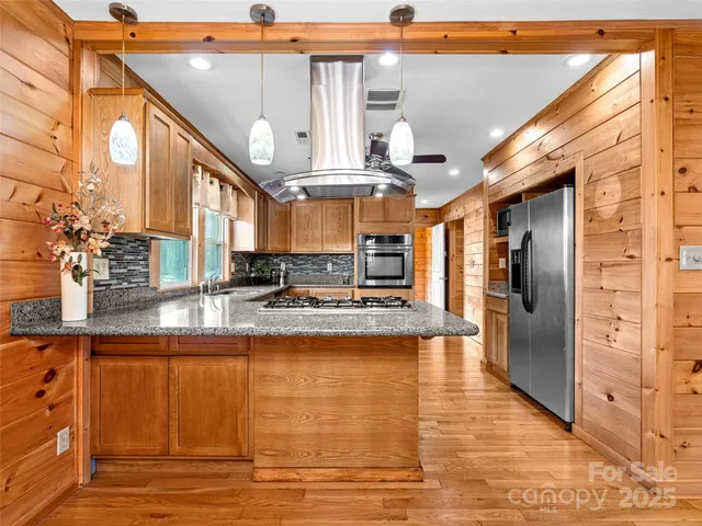 a kitchen with stainless steel appliances granite countertop a stove a sink and a refrigerator
