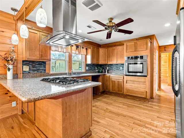 a kitchen with stainless steel appliances a stove a sink and a refrigerator