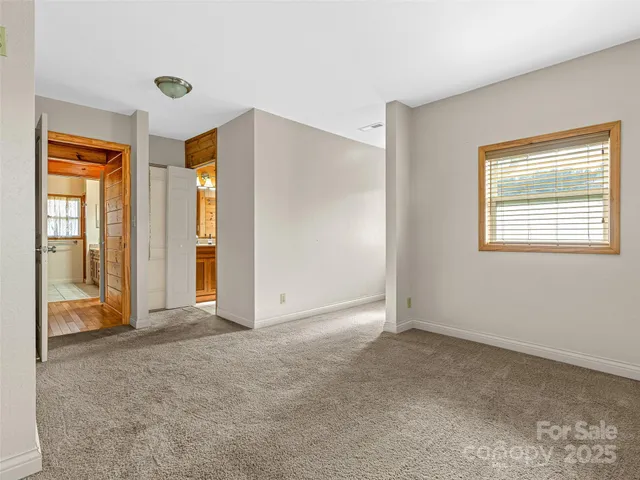 a view of an empty room with window and a livingroom