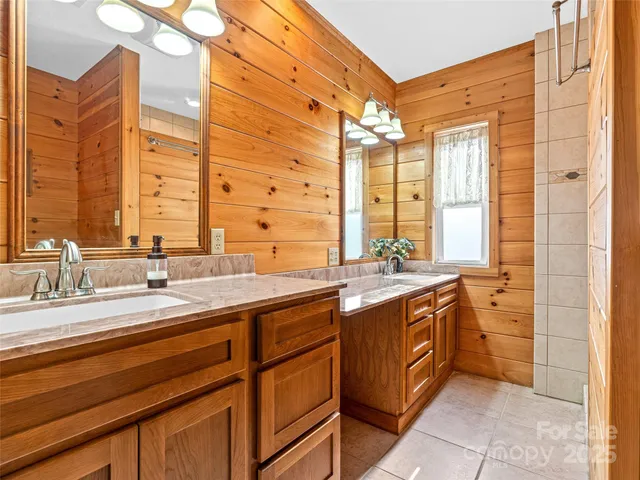 a bathroom with a granite countertop sink a large mirror and a shower