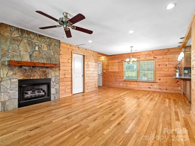 a view of empty room with wooden floor and fireplace