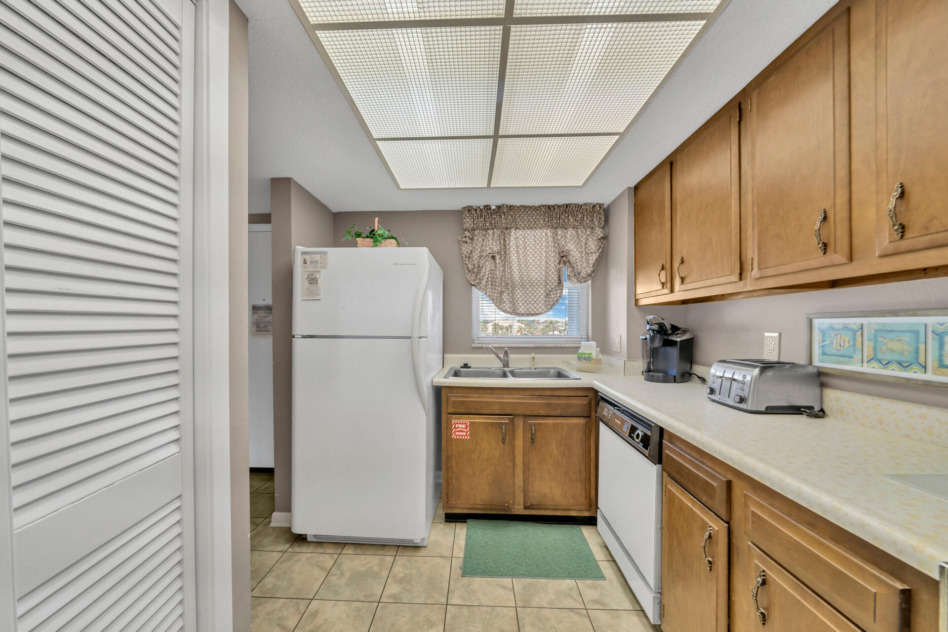 909 Santa Rosa Boulevard, Unit 138 Fort Walton Beach, FL 32548 - Photo 7 of 27 a kitchen with a sink a refrigerator and cabinets
